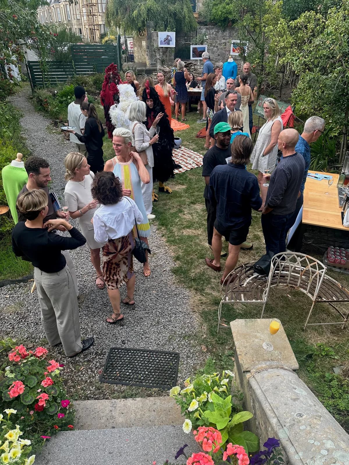Friends and family gathered along the garden path with tables and chairs outside